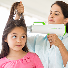 A parent using the OneCure device to treat a child's hair for lice at home